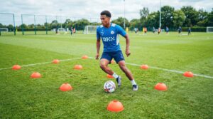 Football player dribbling freely inside a grid to improve creativity and ball control