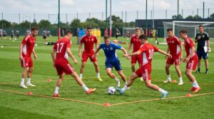 Group of football players doing rondo drill to improve passing and ball control under pressure