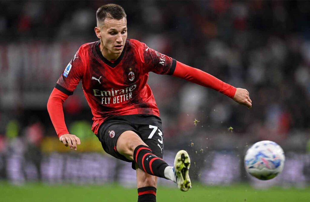 Francesco Camarda strikes a shot on goal in an AC Milan shirt during a Serie A match