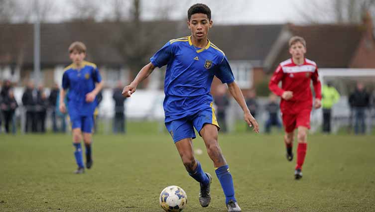 Young Jude Bellingham playing football in a blue Birmingham City youth jersey during his early football career