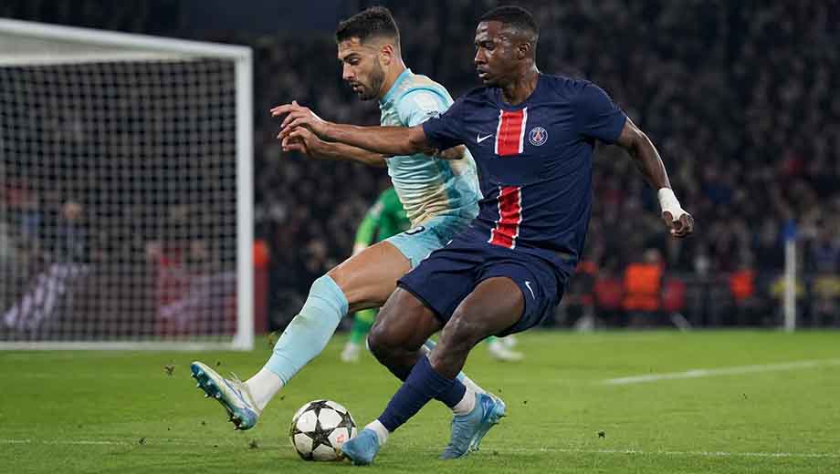 Willian Pacho making a crucial defensive challenge for PSG during a match, one of the top upcoming-defender-2026 talents.